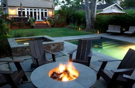 backyard retreat with fancy chairs a firepit and a lap pool How to Create Your Own Backyard Retreat
